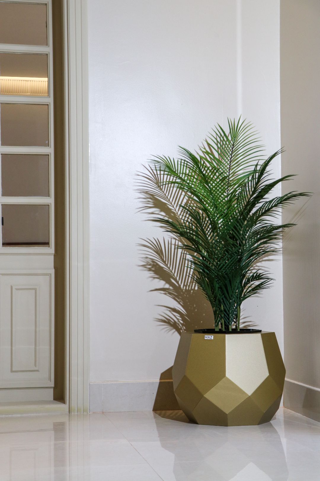 Gold Artichoke vase with areca palm in a villa hallway